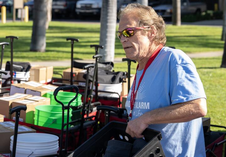 Rick carries a basket of fire alarm supplies
