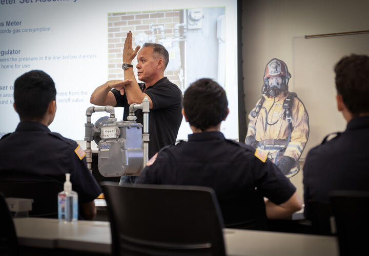 sdge male employee demonstrates gas operations to first responder students in a classroom setting.