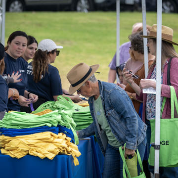 Image of an elderly woman registering at the welcome desk of the SDG&E wildfire safety fair 