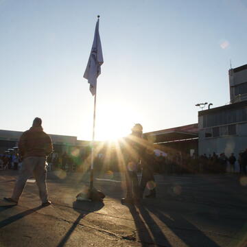 Three crew members observe a recognition flag