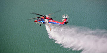 SDG&E's Black Hawk helicopter flying over a lake.