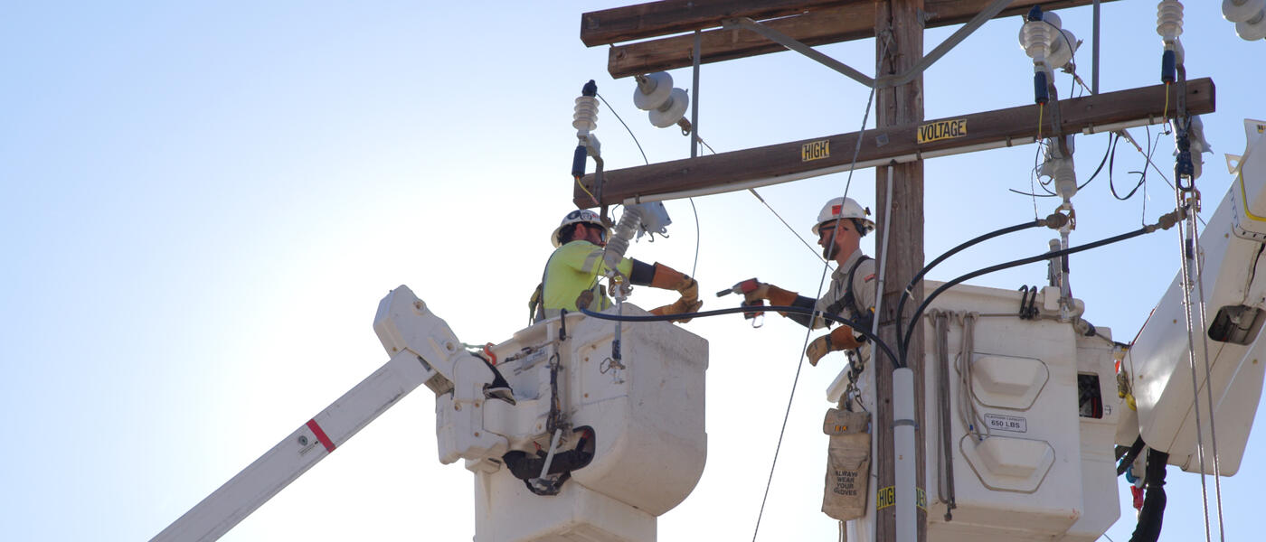 linemen conduct electrical operations from a bucket truck
