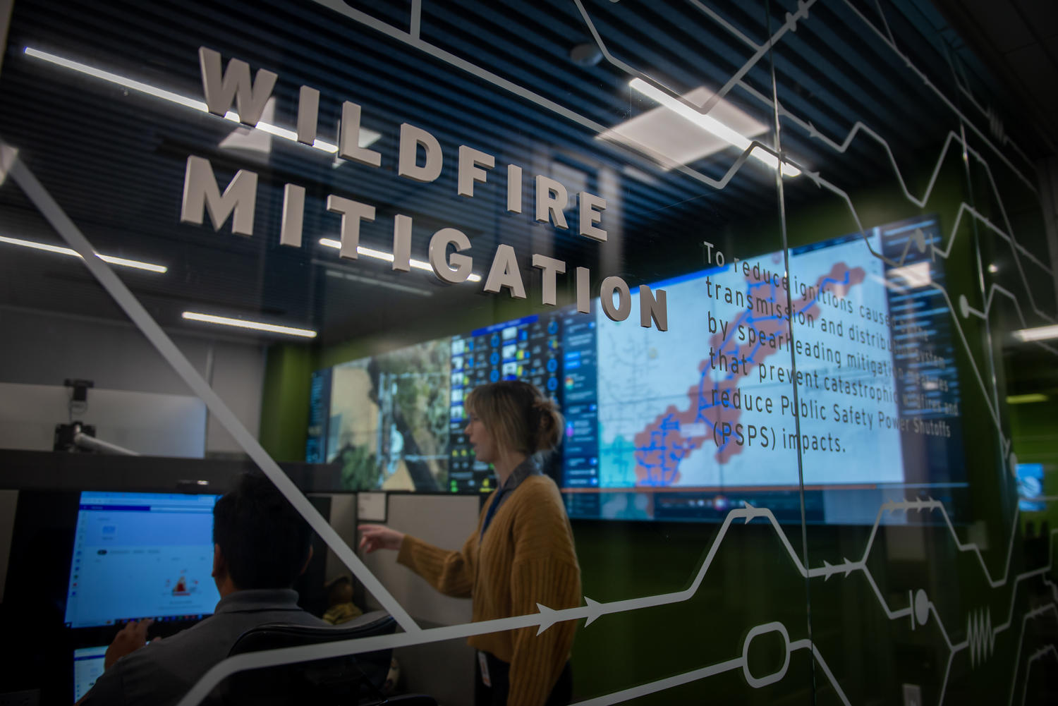 Image of female and male SDG&E employee working within the Wildfire Mitigation workspaces, within the Wildfire Climate and Resilience Center