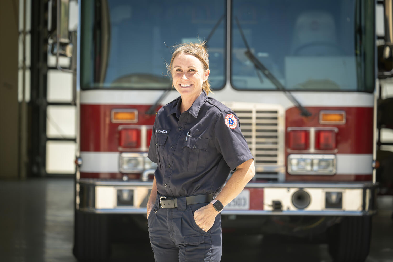 Female fire cadet poses in front of fire engine