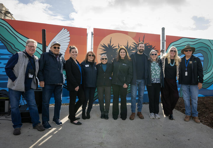 Members of ArtReach and SDG&E pose for a photo in front of the new mural.