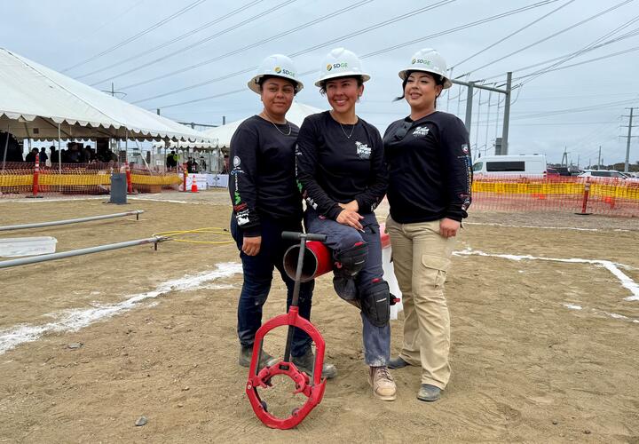 Noelya Collon, Maria Diaz-Gomez y Ernie Guerrero posan para una foto usando cascos de SDG&E.