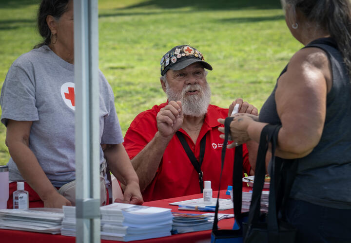 A volunteer with the American Red Cross speaks with a fair attendee.