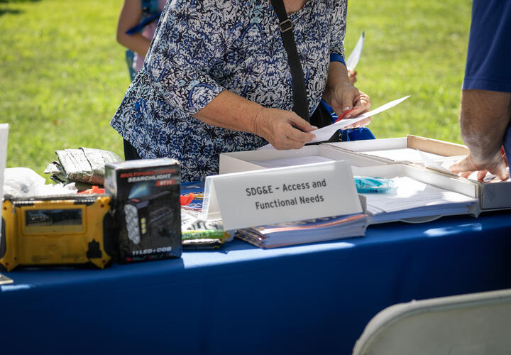 customer receives information at a booth at SDG&E wildfire safety fair