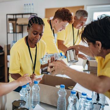 Women and men providing water and other essentials at a Community Resource Center