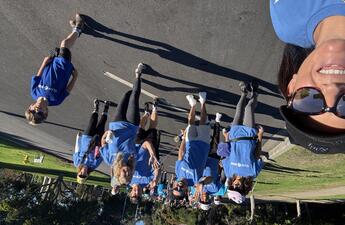 A group of people wearing blue shirts walking through Balboa Park.