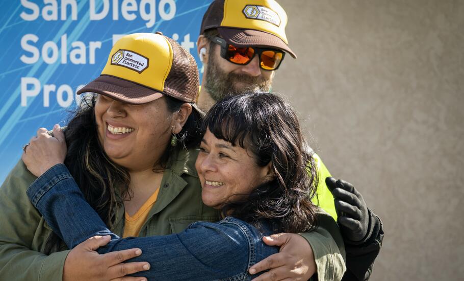 Three people hugging.