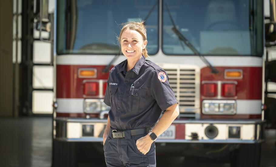 Female fire cadet poses in front of fire engine