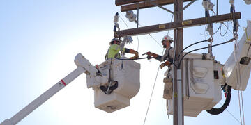 linemen conduct electrical operations from a bucket truck