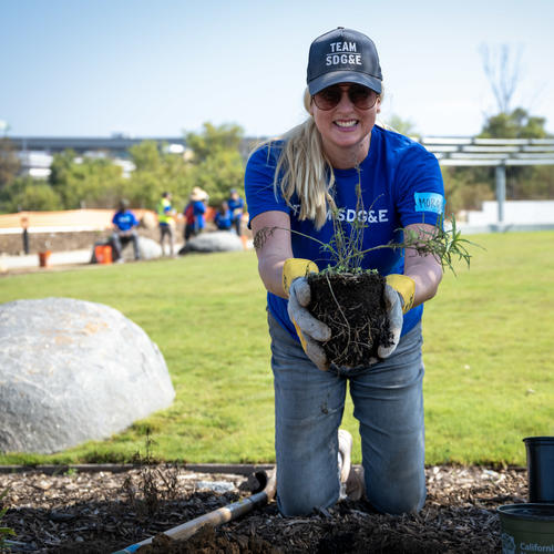 image of female SDGE employee holding a plant. 